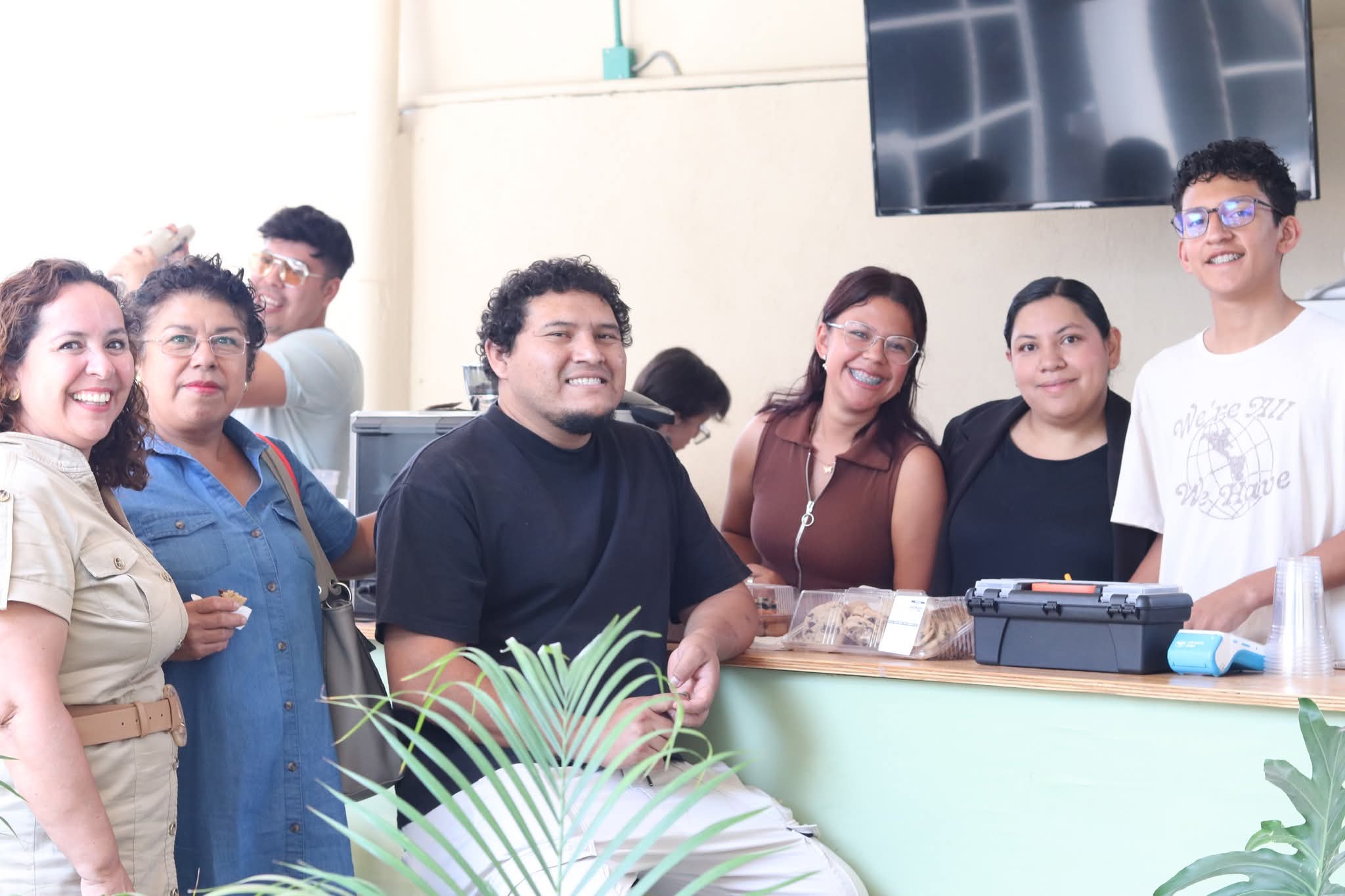Grupo de personas sonriendo en el área de cafetería